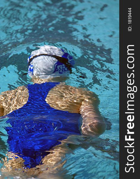 Little girl swimming under water after flip turn at swim meet. Little girl swimming under water after flip turn at swim meet.