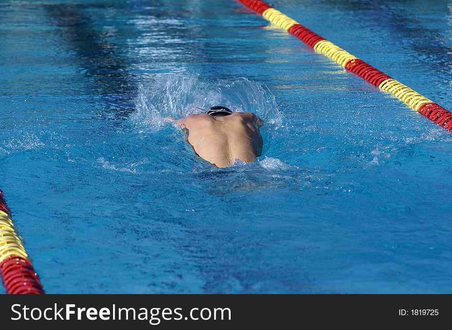 Young man swimming the butterfly event at a swim meet. Young man swimming the butterfly event at a swim meet.