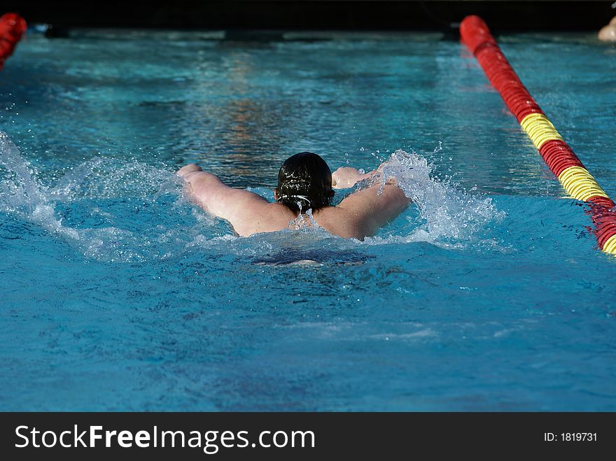 Young man swimming the butterfly event at a swim meet. Young man swimming the butterfly event at a swim meet.