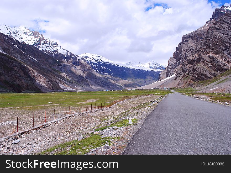 A road leading to a beautiful snow peaks and mountains in a Himalayan valley. A road leading to a beautiful snow peaks and mountains in a Himalayan valley.