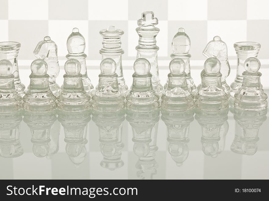 Beautiful glass chess on a white background. Photo taken in the studio on a glass countertop. Beautiful glass chess on a white background. Photo taken in the studio on a glass countertop.