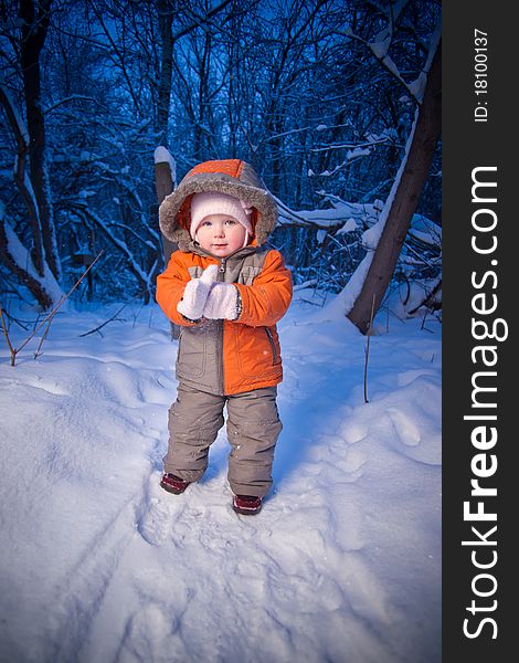 Adorable baby walking in evening park. Putting on mittens. Adorable baby walking in evening park. Putting on mittens