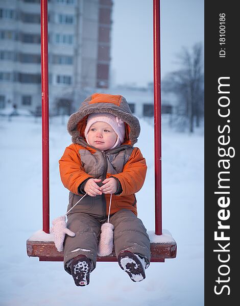 Cute baby sit on swing on playground