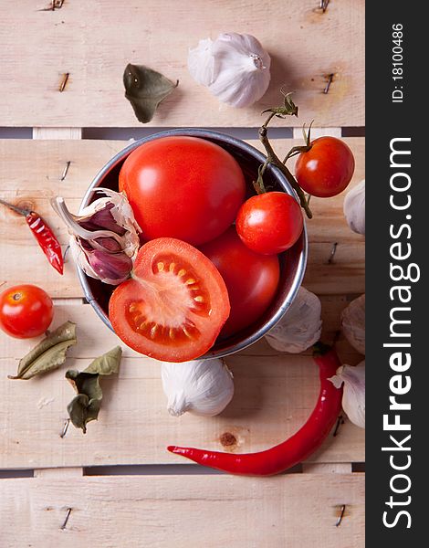 Tomato, garlic and pepper on a wooden desk