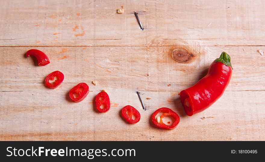 Sliced red hot chili pepper on wooden desk. Sliced red hot chili pepper on wooden desk
