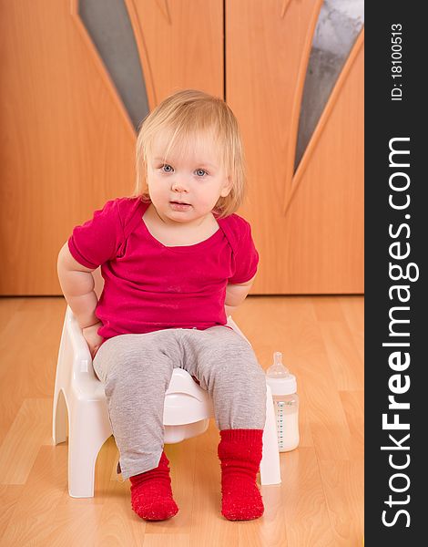 Adorable baby sit on baby chair toilet. Adorable baby sit on baby chair toilet