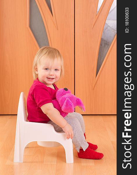 Adorable baby sit on toilet chair with cute pink toy dog. Adorable baby sit on toilet chair with cute pink toy dog