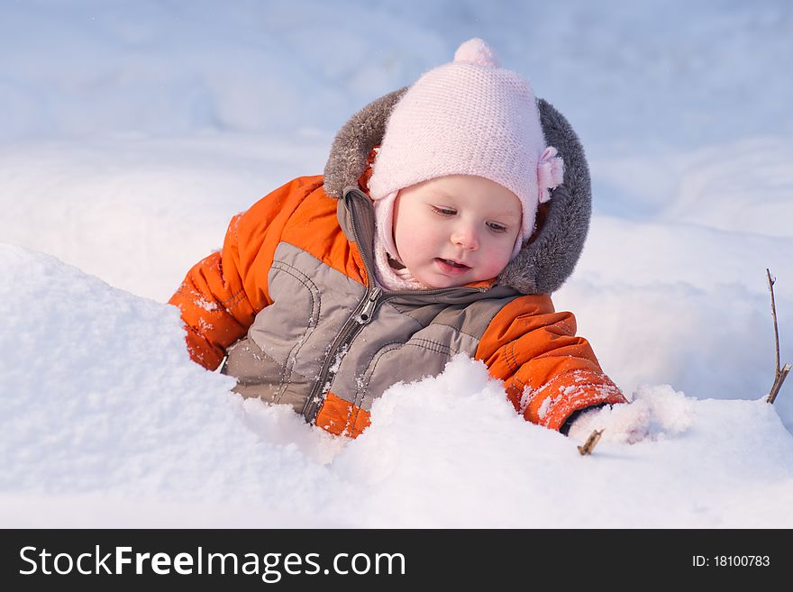 Cute baby sit in snow in forest and dig snow