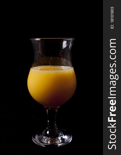 Glass of orange juice over black background