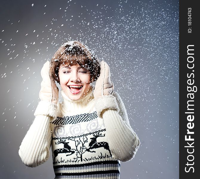 Young beautiful girl rejoices to snow, On a dark blue background