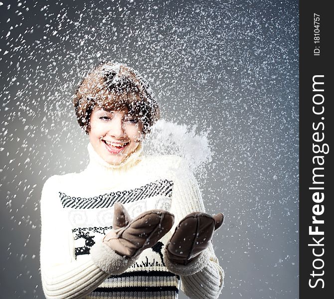 Young beautiful girl rejoices to snow, On a dark blue background