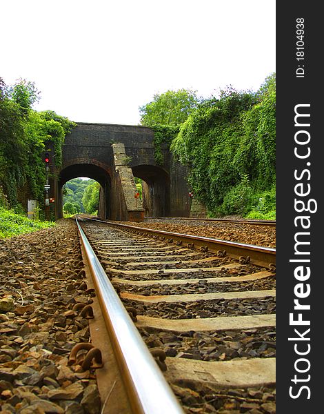 A low view of a railway line leading under a viaduct. A low view of a railway line leading under a viaduct