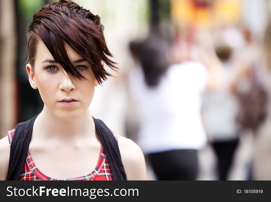 Young modern looking girl over urban background. Young modern looking girl over urban background