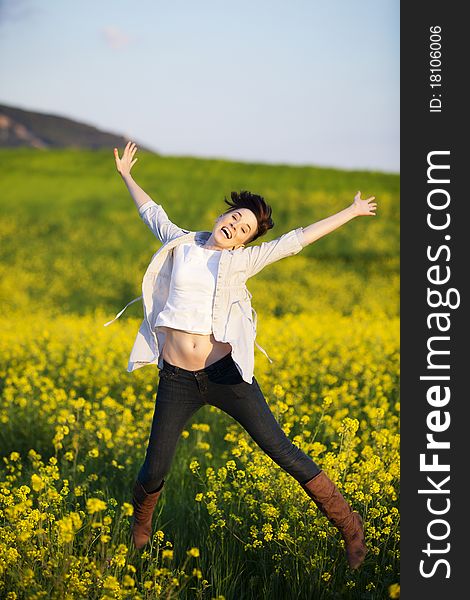 Cheerful jumping girl in spring background.