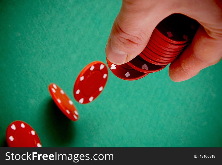 Red gambling chips falling from men hand