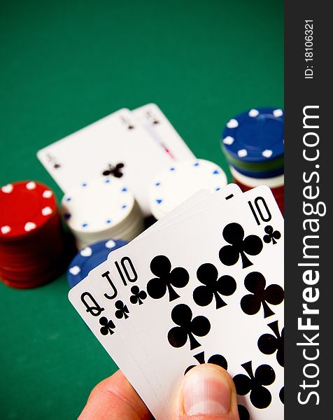 Playing cards and gambling chips on green background