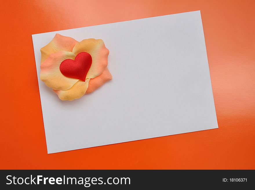 White card with rose petals. Postcard with heart on the orange background. White card with rose petals. Postcard with heart on the orange background.