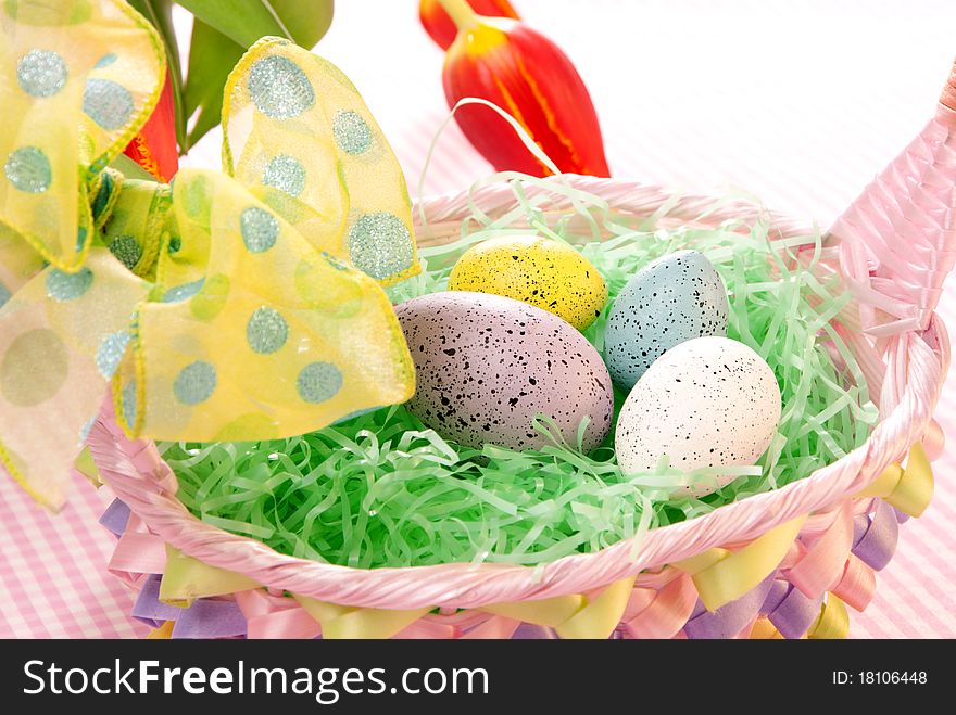 Easter blue, pink, yellow Painted Colorful eggs in basket with spring tulips on a pastel background. Easter blue, pink, yellow Painted Colorful eggs in basket with spring tulips on a pastel background