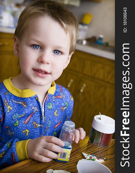 Boy Decorating Christmas Cookies with colored sprinkles. Boy Decorating Christmas Cookies with colored sprinkles