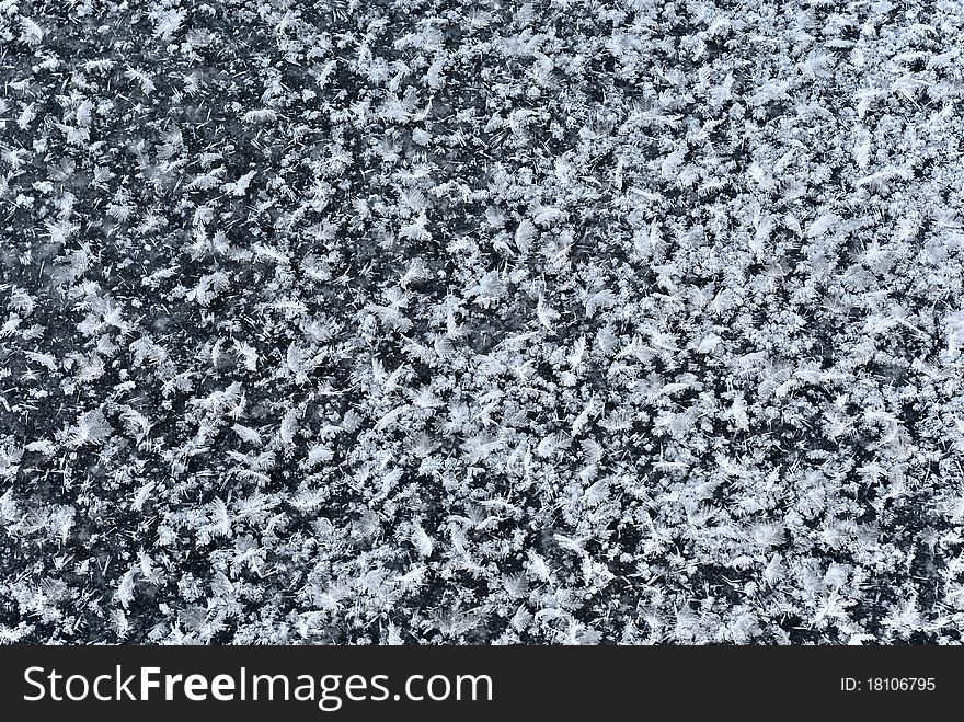 Abstract pattern of snow flakes on black ice similar to scattered bird's feathers. Abstract pattern of snow flakes on black ice similar to scattered bird's feathers