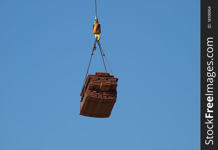 Crane liting cargo of planks