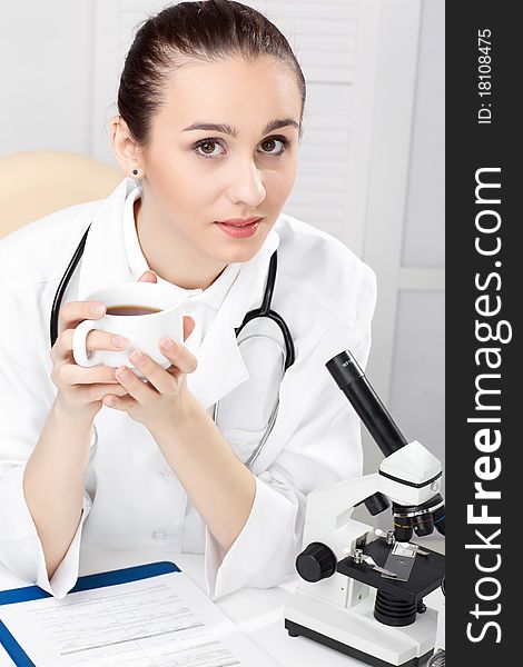 Female medical doctor working with a microscope. Female medical doctor working with a microscope