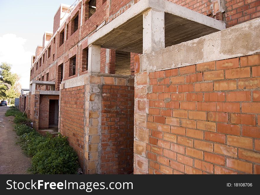 Building in red brick works unfinished by the crisis. Building in red brick works unfinished by the crisis