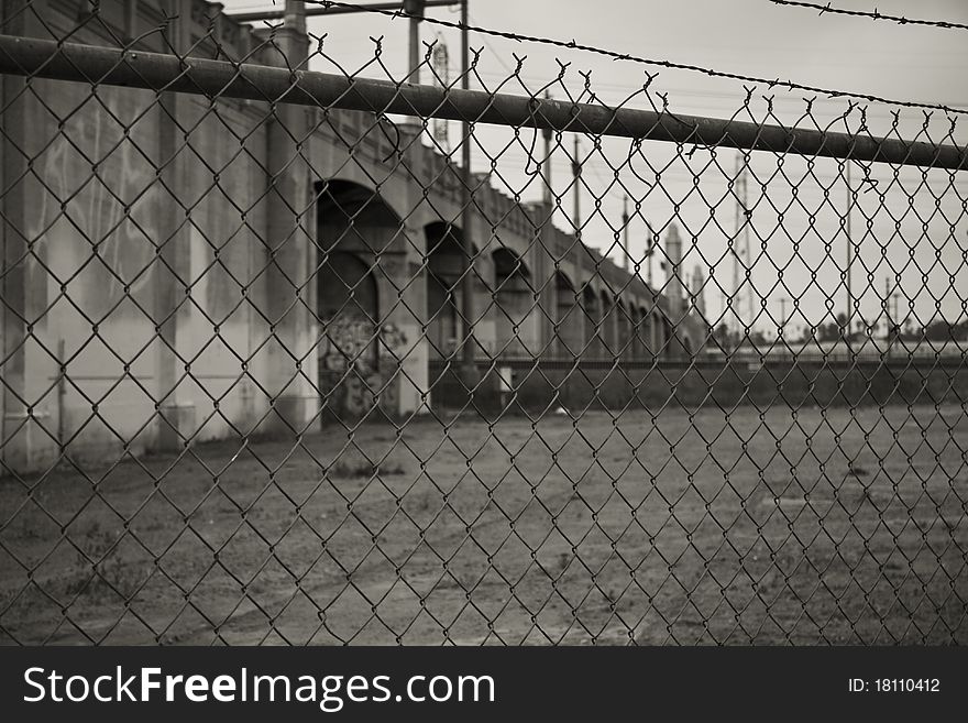 A bridge over the Los Angeles River, behind chain link fence. A bridge over the Los Angeles River, behind chain link fence.