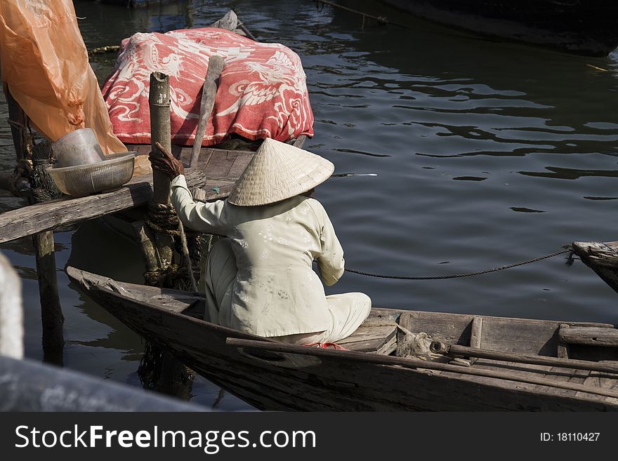 An old Vietnamese woman sits in a boat. An old Vietnamese woman sits in a boat.