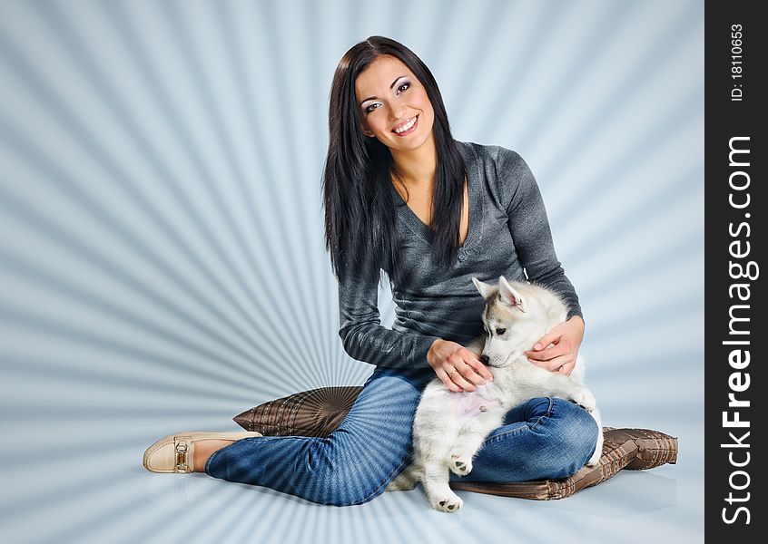 Playing woman with puppies of siberian haski on blue background with jalousie effect. Playing woman with puppies of siberian haski on blue background with jalousie effect