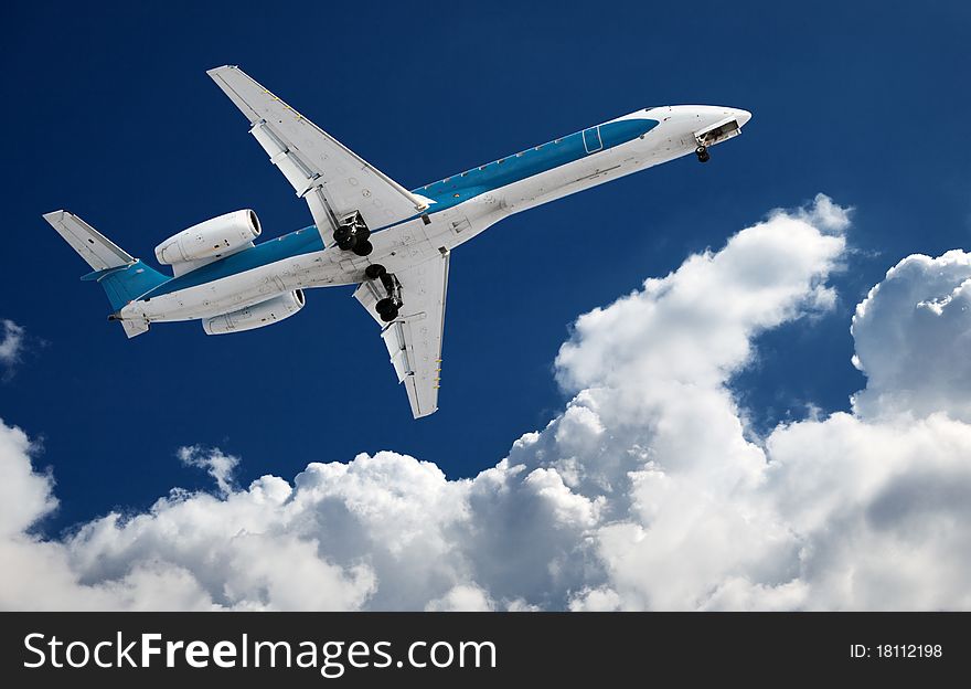 Big airliner in the blue sky with clouds.