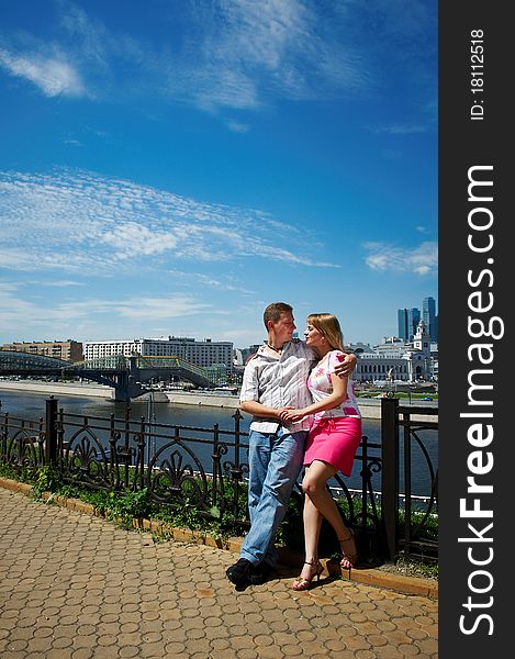 Young happy man and woman at romantic walk on the embankment of the Moskva River