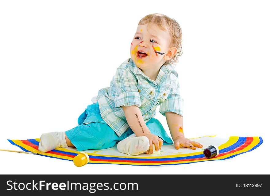 Beautiful baby covered in bright paint with paint brush. Isolated.