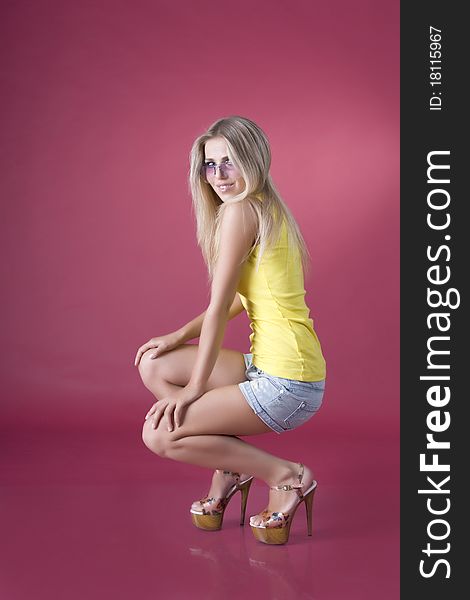 Glamour girl wearing spectacles on a red background