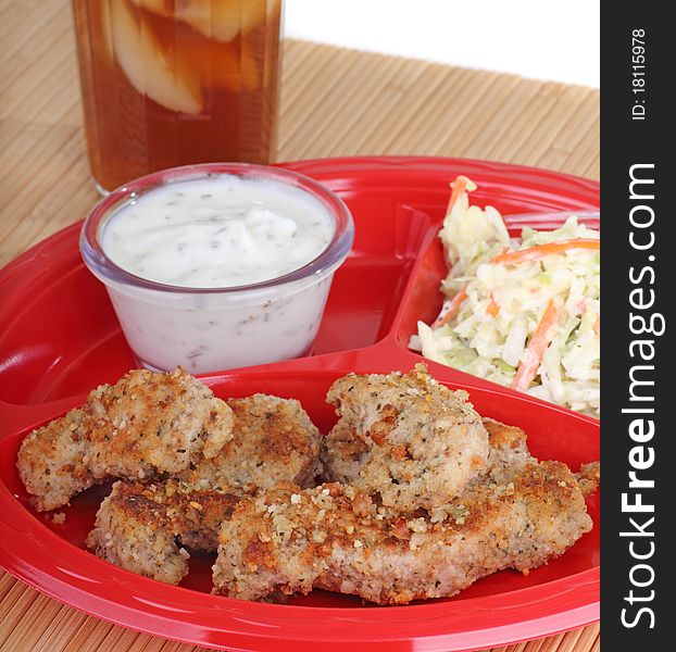Chicken strips with coleslaw and sauce and a drink