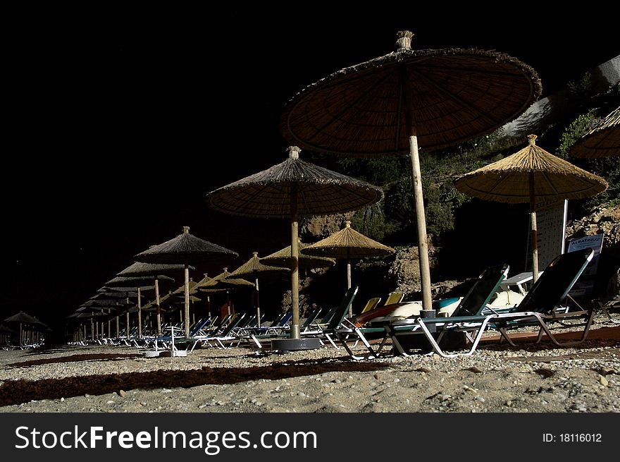 Beach umbrellas and chairs at night