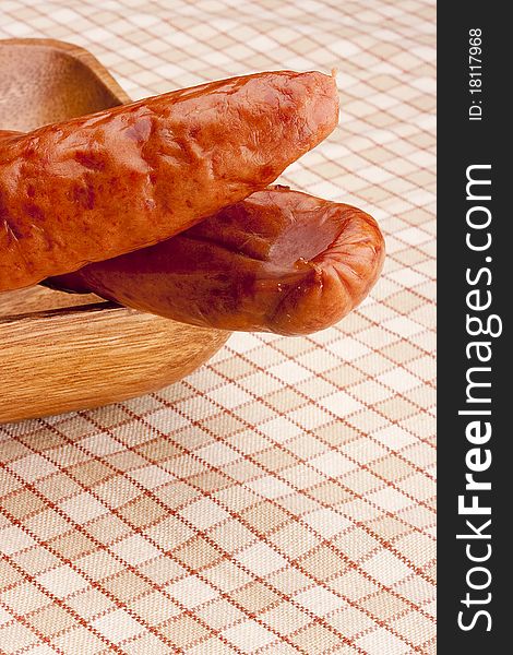 Smoked sausage on a background of cellular tissue.