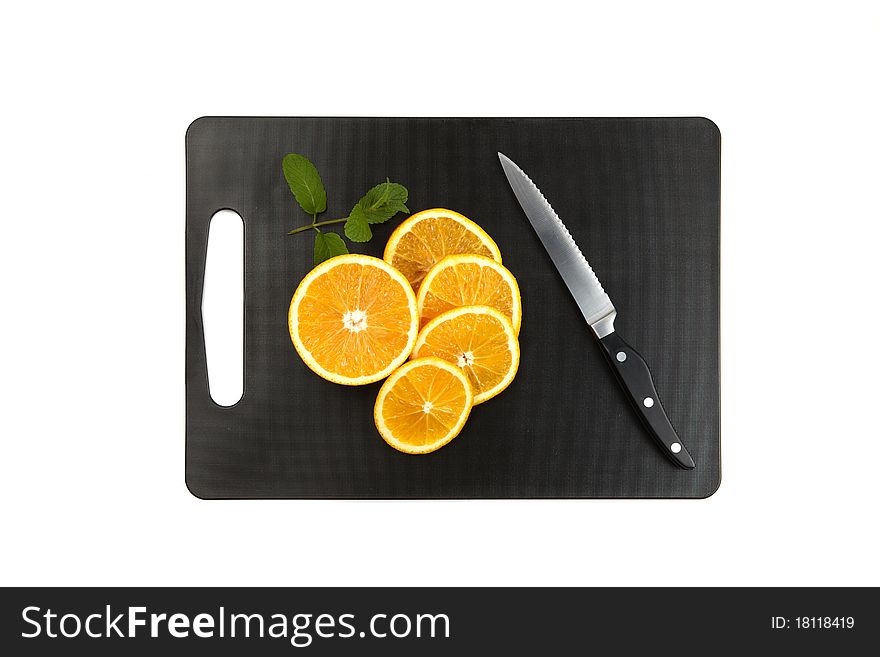 Black cutting board with oranges, mintleaf and knife isolated on white background. Black cutting board with oranges, mintleaf and knife isolated on white background