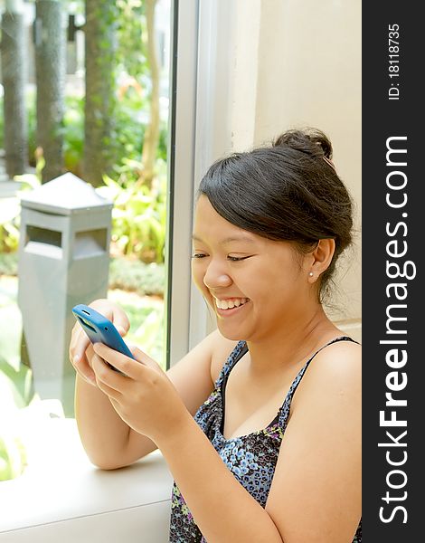 Asian ethnic young woman happy using cell phone. Asian ethnic young woman happy using cell phone