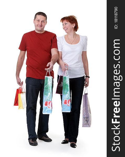 Young couple with shopping bags on white background