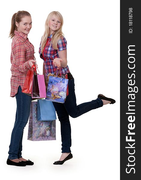 Two young beautiful girls on shopping on a white background