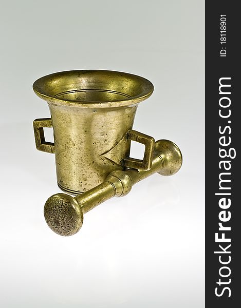 Old brass mortar with pestle on white