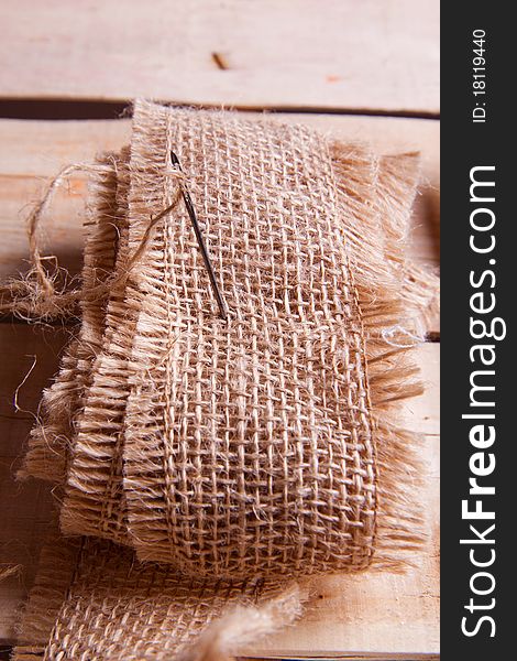 Needle and jute thread on wooden desk. Needle and jute thread on wooden desk