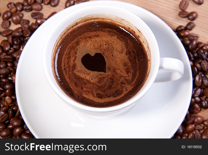 White cup of black coffee with little heart on coating. For themes like love, valentine's day