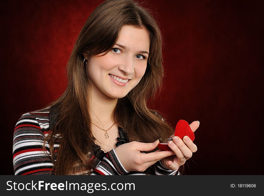 Beautiful woman with a heart gift on the red background. Beautiful woman with a heart gift on the red background