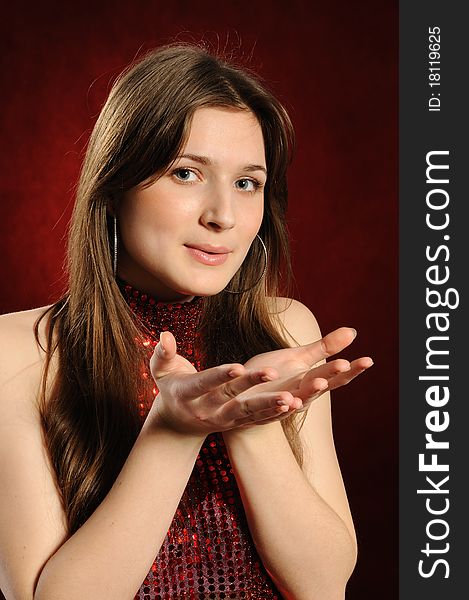 Young woman holding hand presenting a product.On a red background