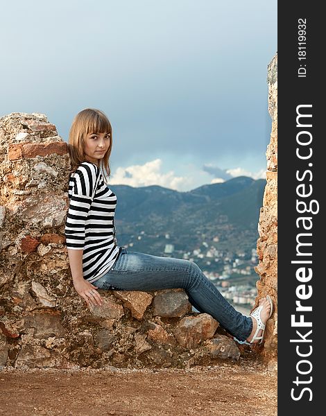 Beautiful girl on the wall of an old fortress