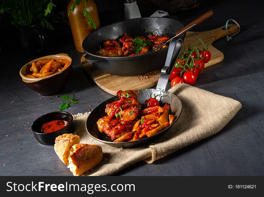A Rustic chicken wings in honey with potato wedges