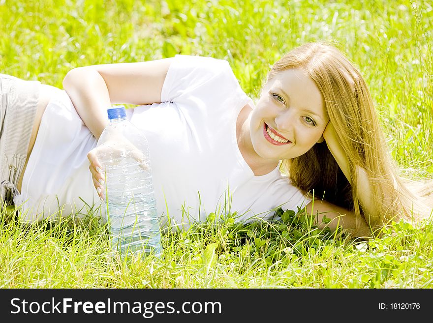 Lying young woman with bottle of water