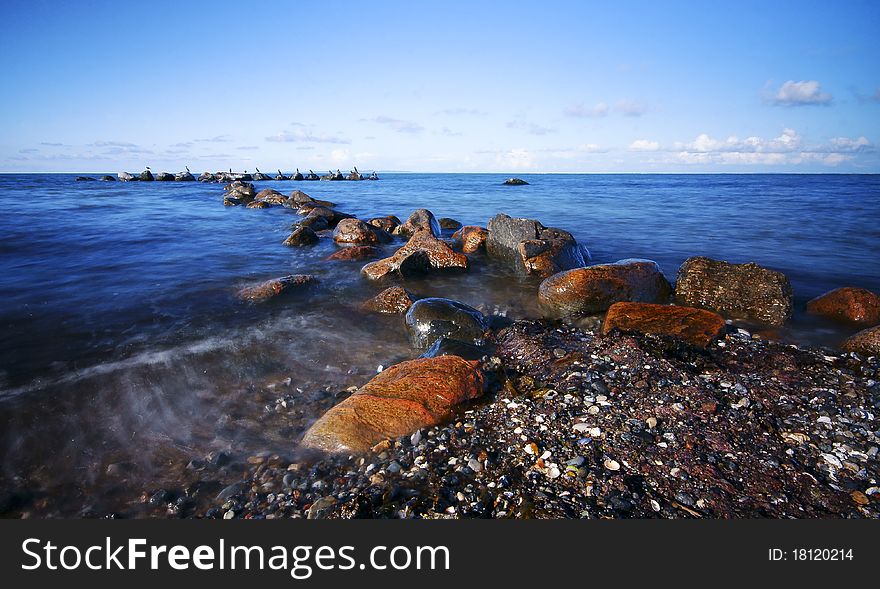 Seascape with rocks and birds in the distance. Seascape with rocks and birds in the distance.